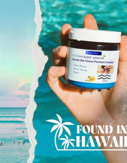 Dropdash Ocean Bee Venom Psoriasis Cream in a hand against a tropical beach background