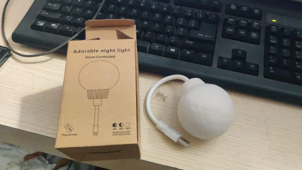 White spherical USB moon light with cord and box on desk next to keyboard 3D moon lamp for home decor