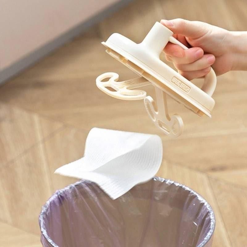 Beige THE GIR FARMER disposable cleaning brush with handle holding single use wipe above trash for quick floor cleanup