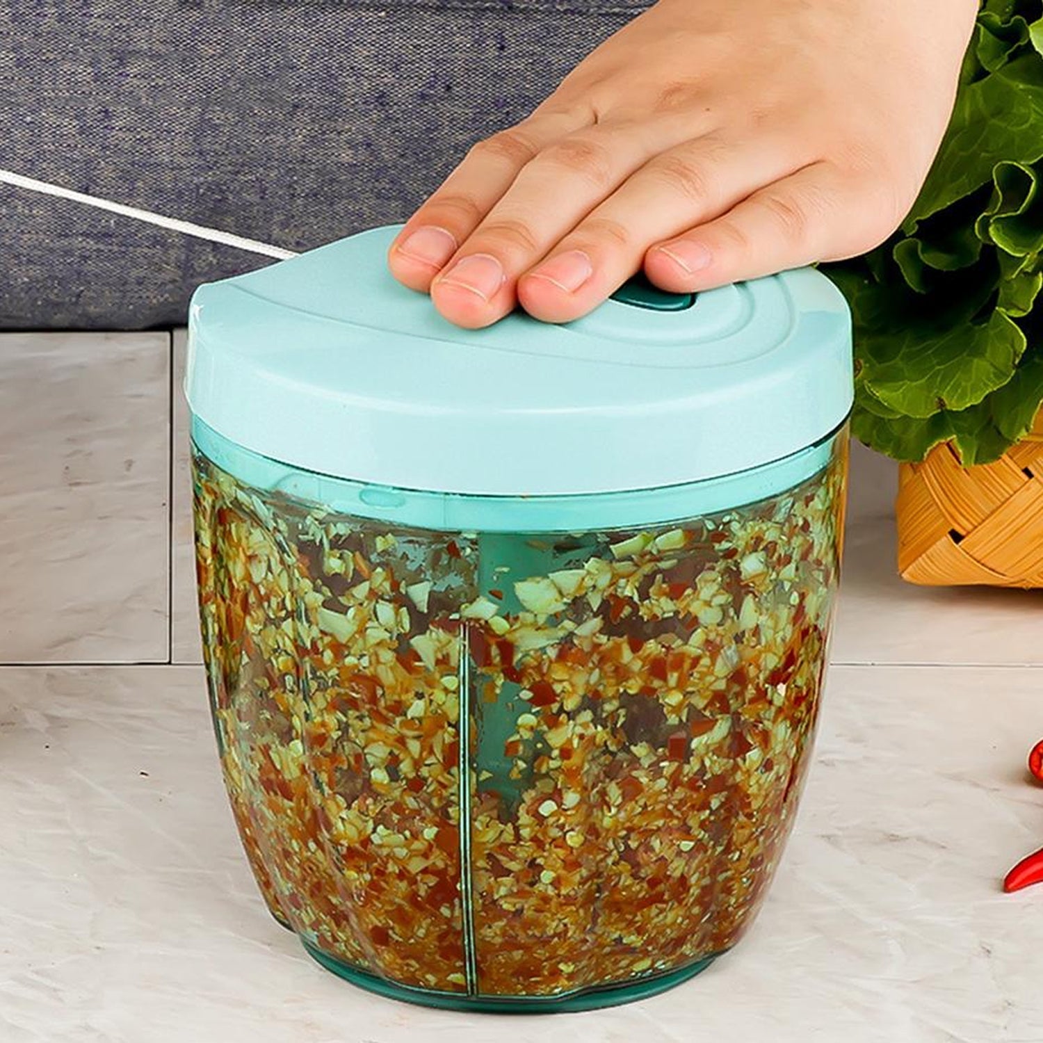 Manual stainless steel vegetable chopper with a turquoise lid for easy food preparation and slicing