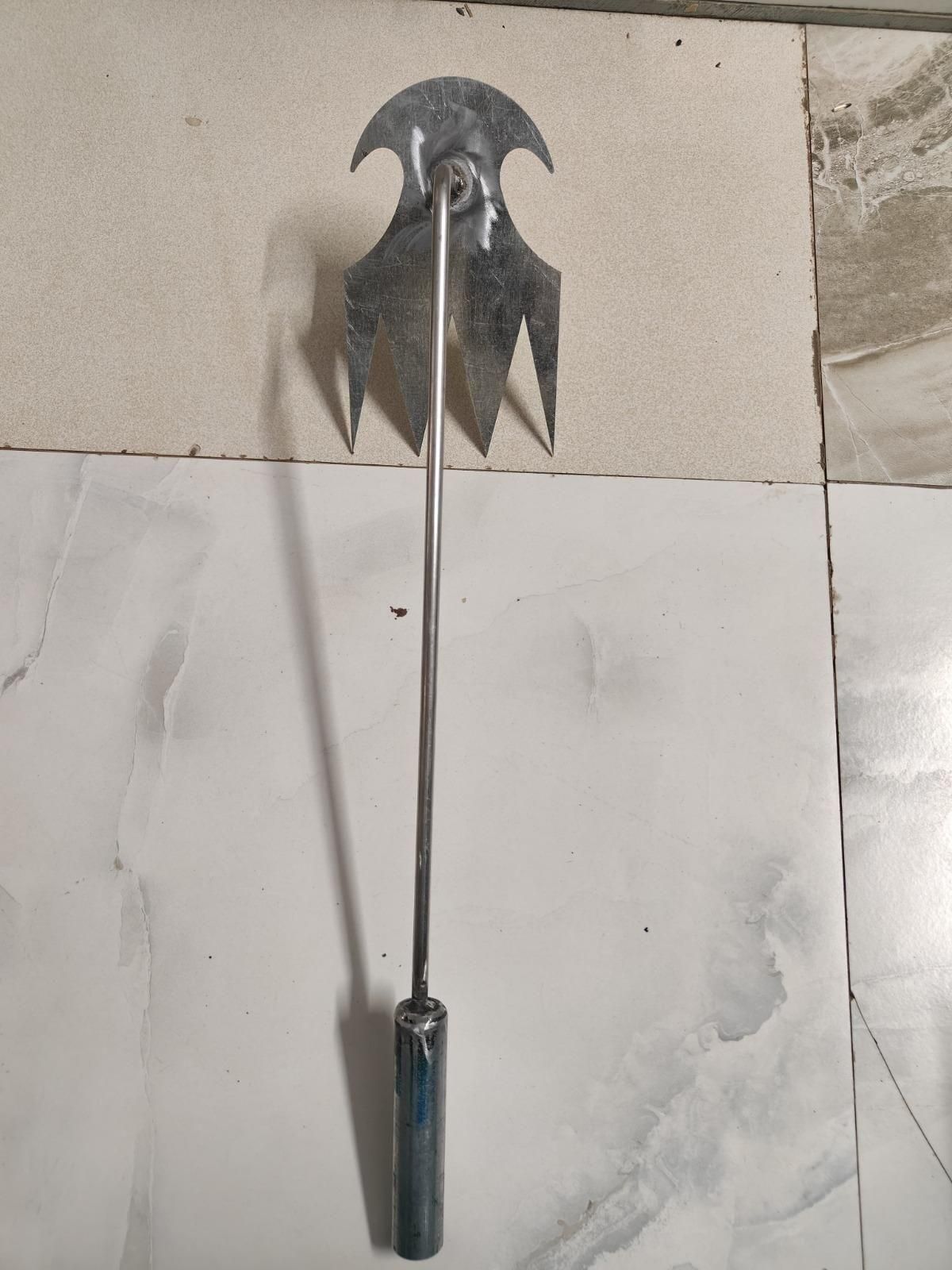Manual weed remover for small farms with metal handle and multi-pronged blade for effective weeding