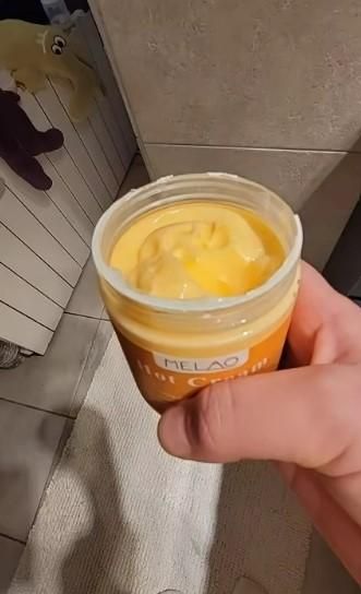 Organic body care hot cream in a jar, showcasing a rich yellow texture for soothing skin benefits