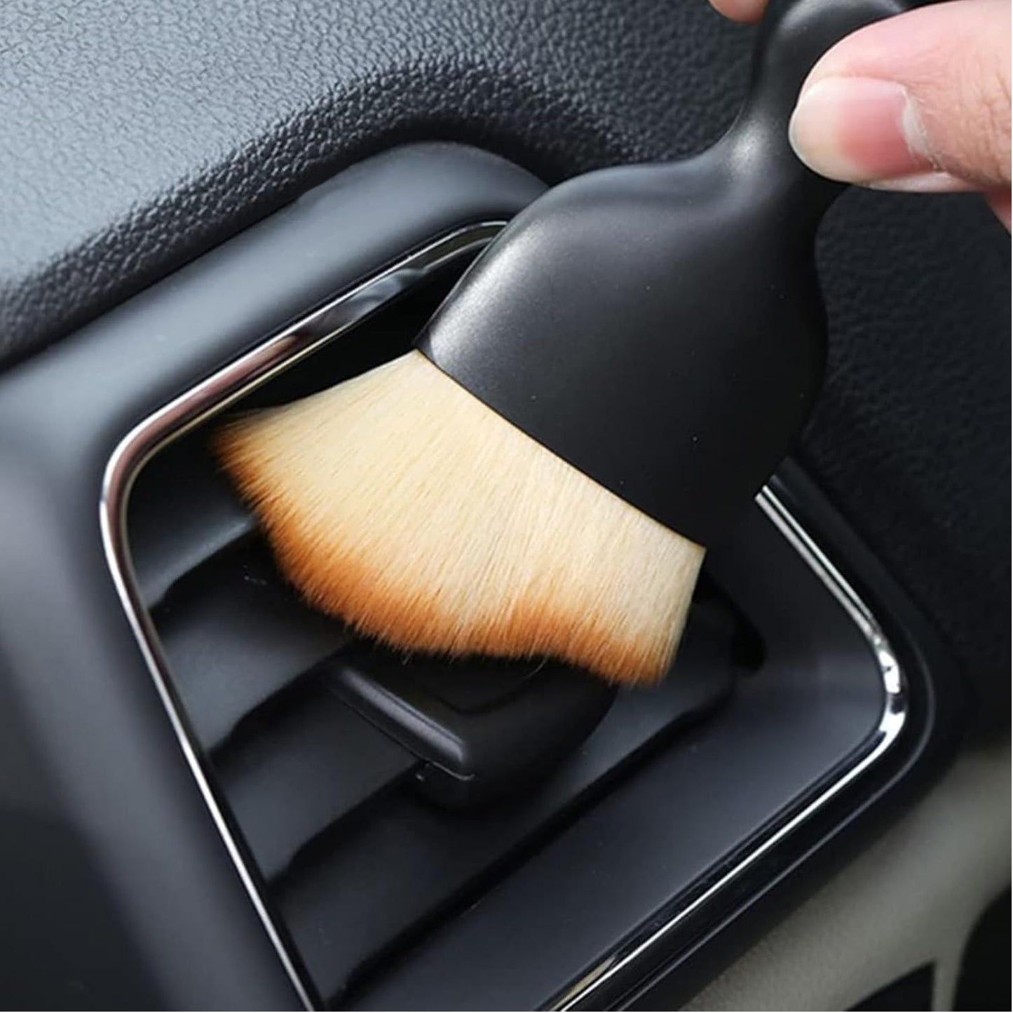 Mini car interior cleaning brush gently removing dust from air vent in a vehicle