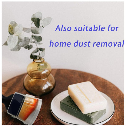 Mini car interior cleaning brush on a table with soap and a decorative plant for effective dust removal
