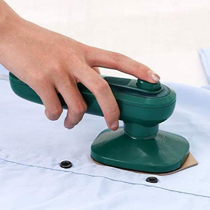 THE GIR FARMER mini garment steamer for home and travel in green held over light blue shirt