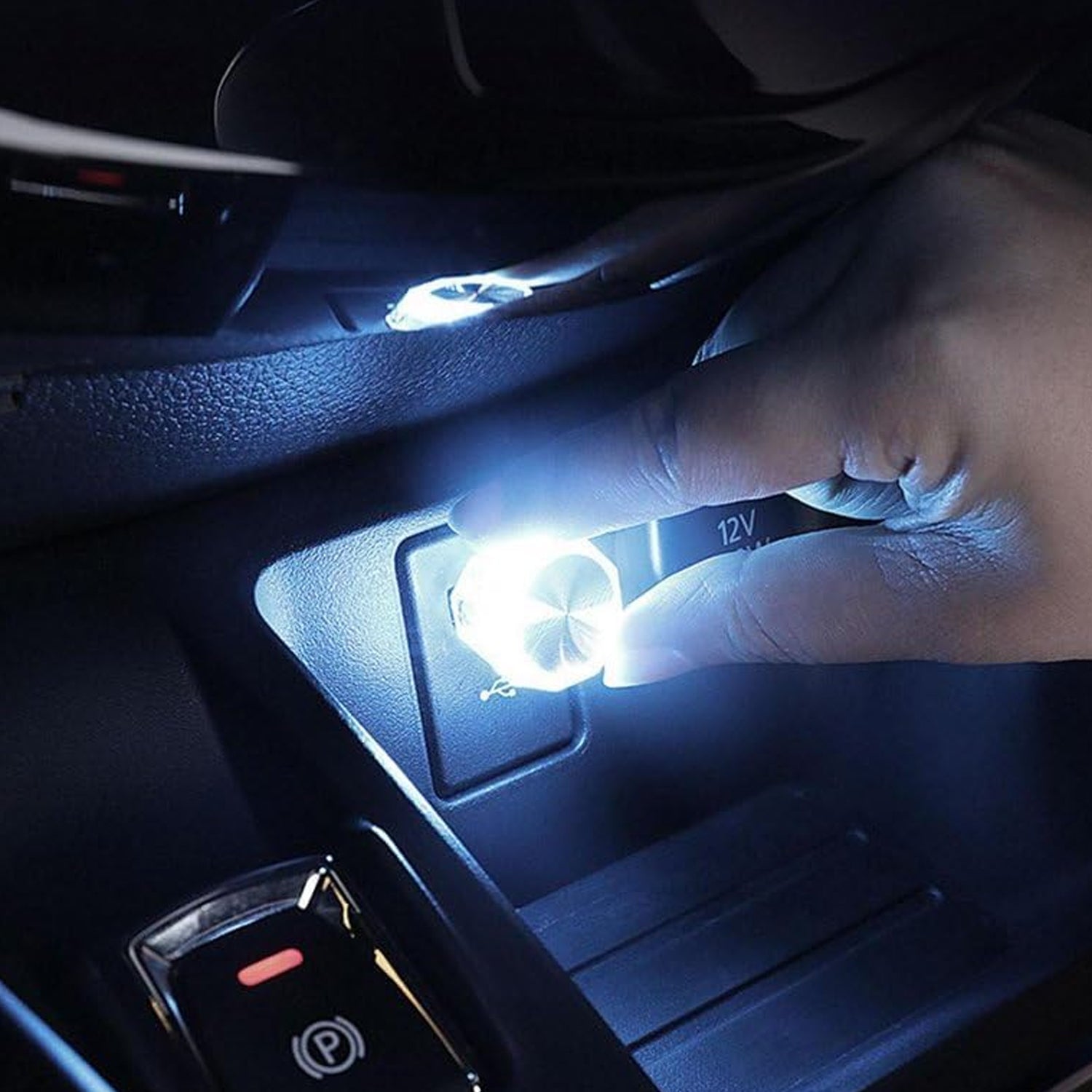 Hand installing a mini USB LED car light into a vehicle's interior for improved visibility