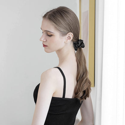 Woman with long brown hair wearing a black mulberry silk elastic band for hair holding a ponytail