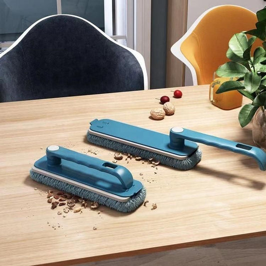 Blue multi-purpose cleaning brush for home on wooden table cleaning nuts and crumbs