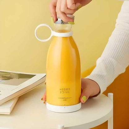 Yellow compact blender for travel with a white handle and lid held by person with yellow nails