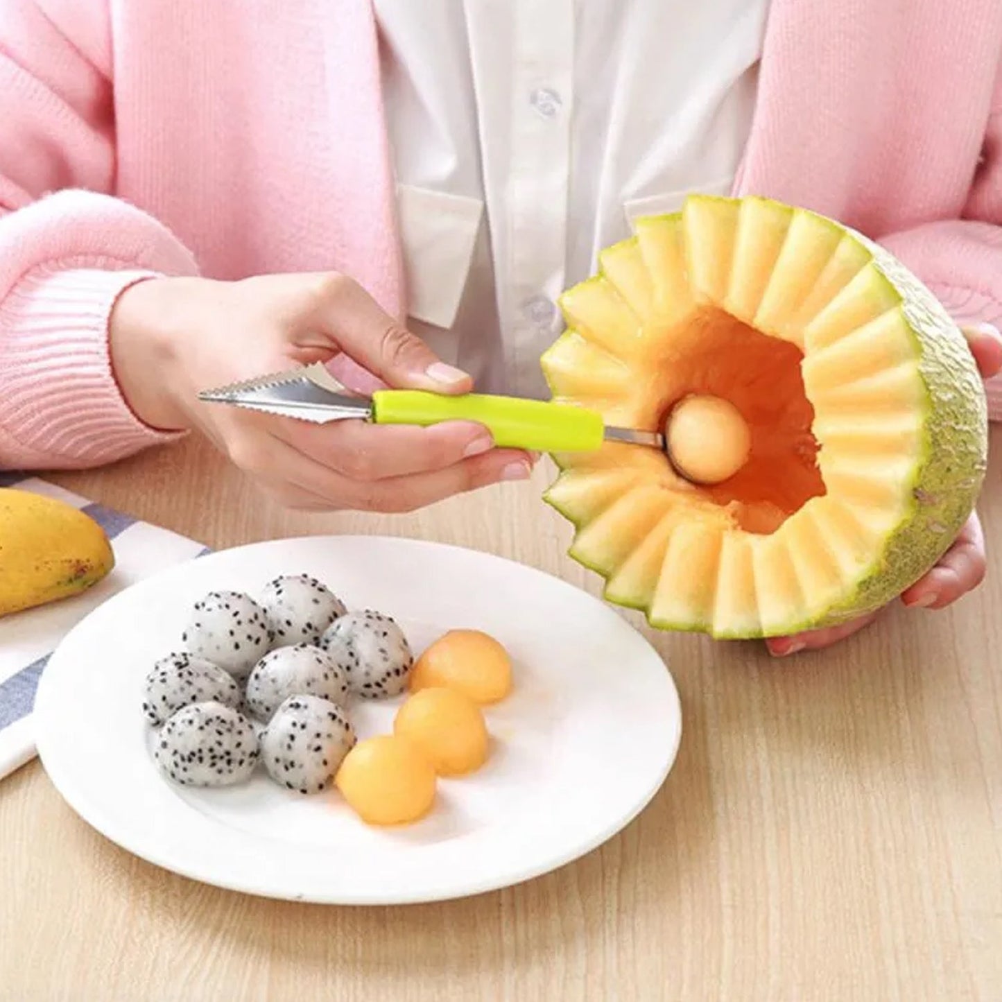 Quickslice multifunctional fruit scooper carving fresh melon and serving fruit balls on a plate