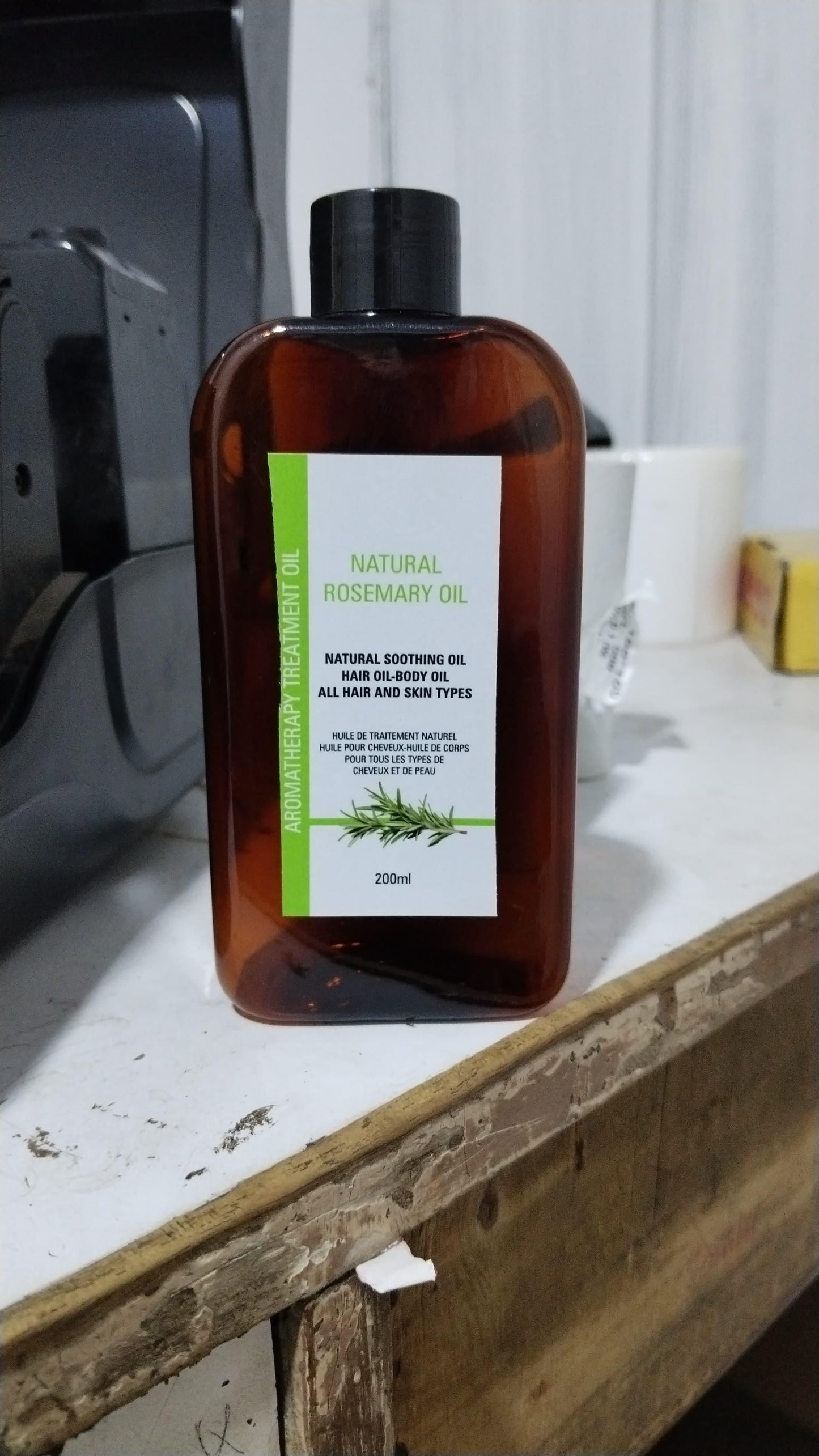 Natural Rosemary Oil for Hair Growth in a 200ml amber bottle on a wooden surface