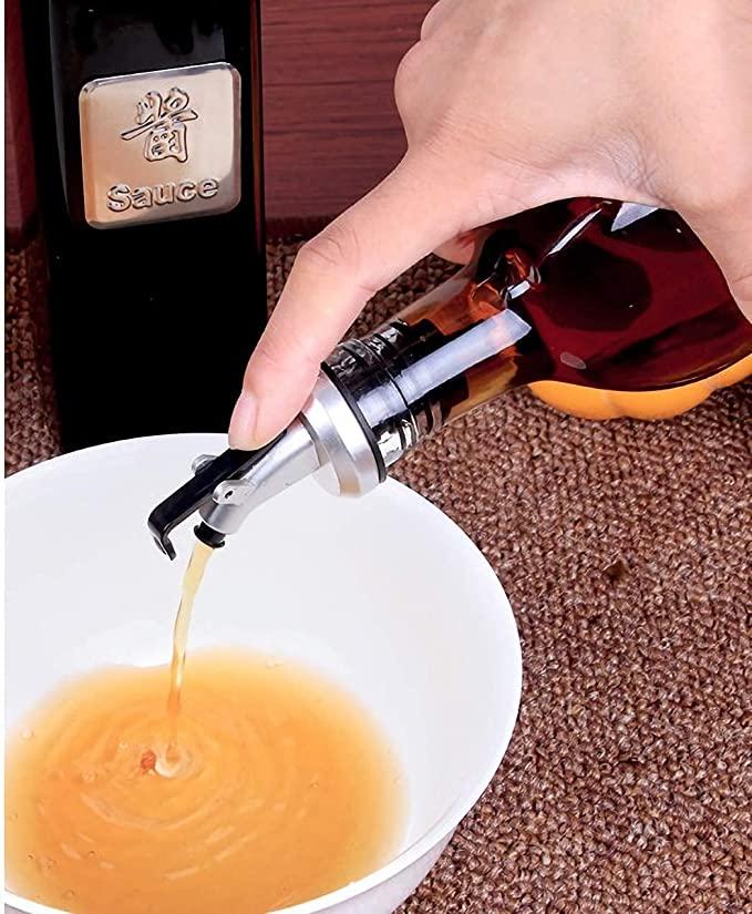 Hand pouring oil from a stylish oil dispenser bottle for kitchen into a white bowl