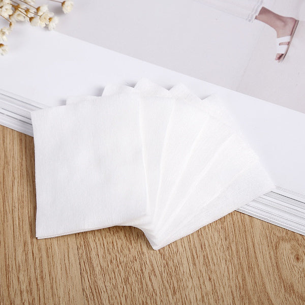 Set of organic cotton makeup remover pads arranged neatly on a wooden table for gentle skincare routine