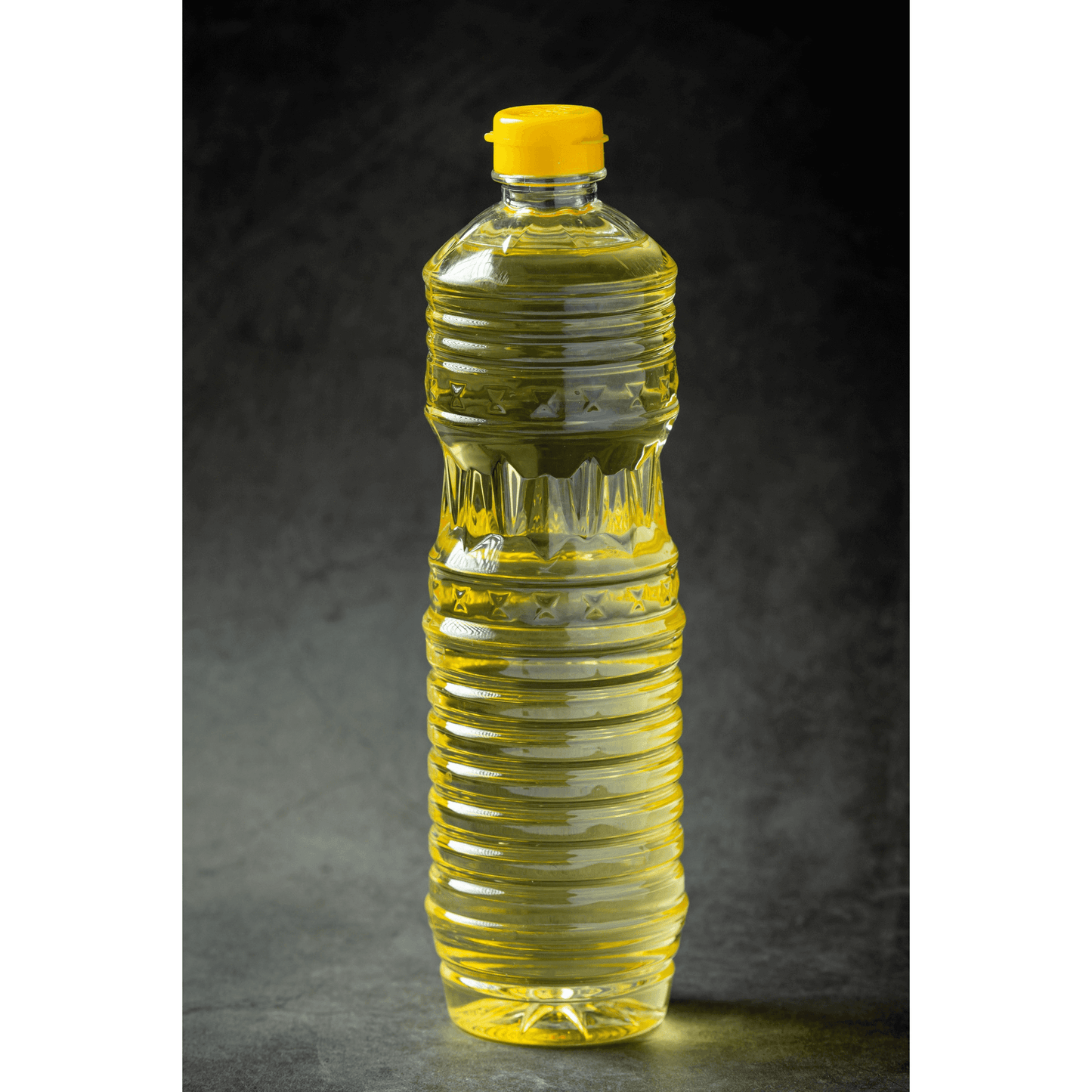 Transparent bottle of yellow organic groundnut cooking oil for healthy culinary use