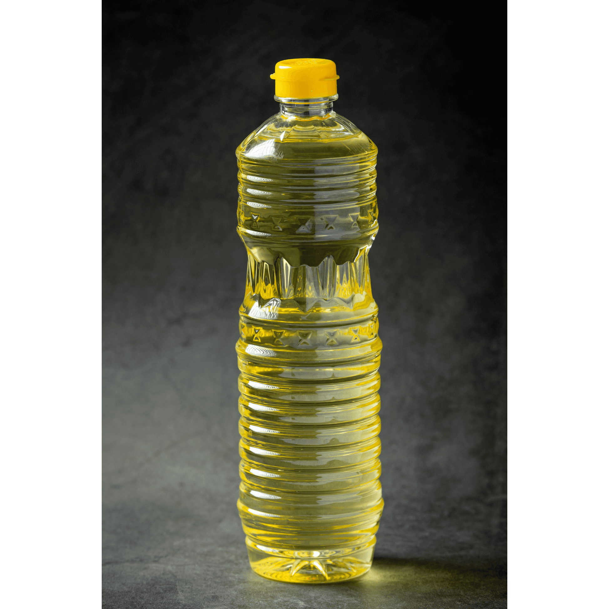 Transparent bottle of yellow organic groundnut cooking oil for healthy culinary use
