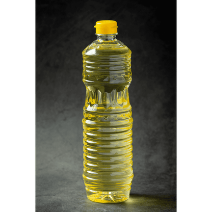 Transparent bottle of yellow organic groundnut cooking oil for healthy culinary use