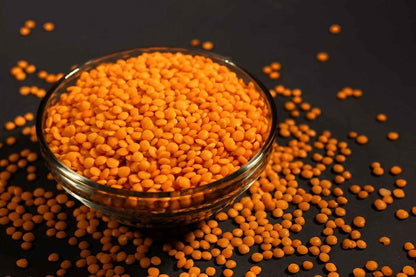 Bowl of organic masoor dal with vibrant orange color, perfect for healthy soups and stews