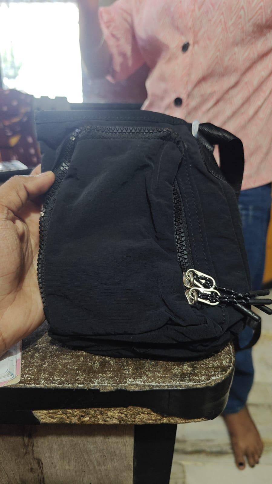 Black organic side sling pouch with multiple zippered pockets for convenience and style