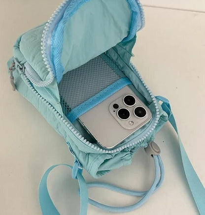 Light blue organic side sling pouch with phone compartment and mesh pocket for accessories