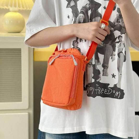 Bright orange organic side sling pouch with adjustable strap and zipper closure for everyday use