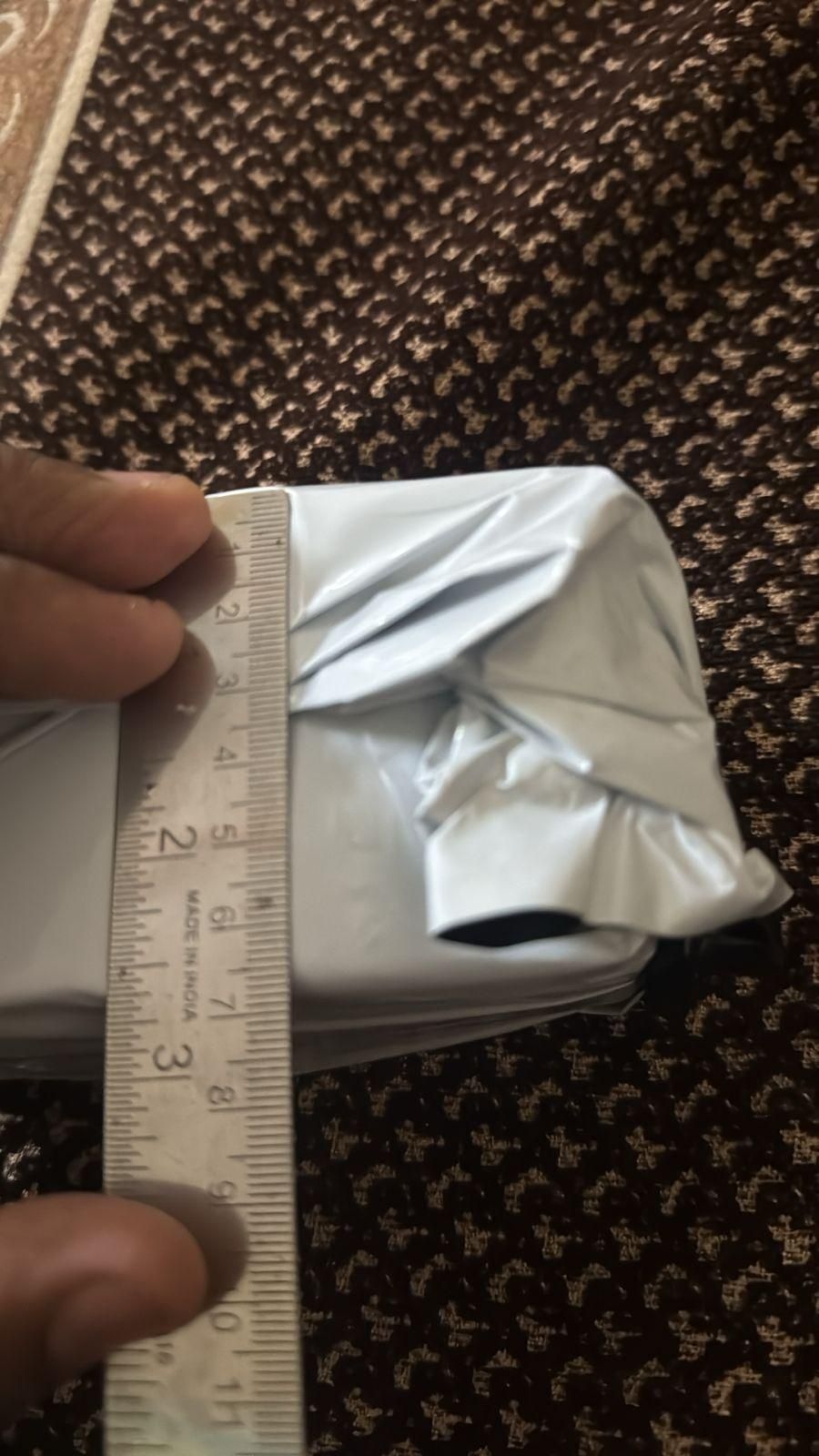 Bee venom skin cream packaging being measured with a ruler for size reference