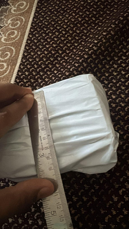 Unboxed bee venom skin cream package being measured with a ruler for size reference