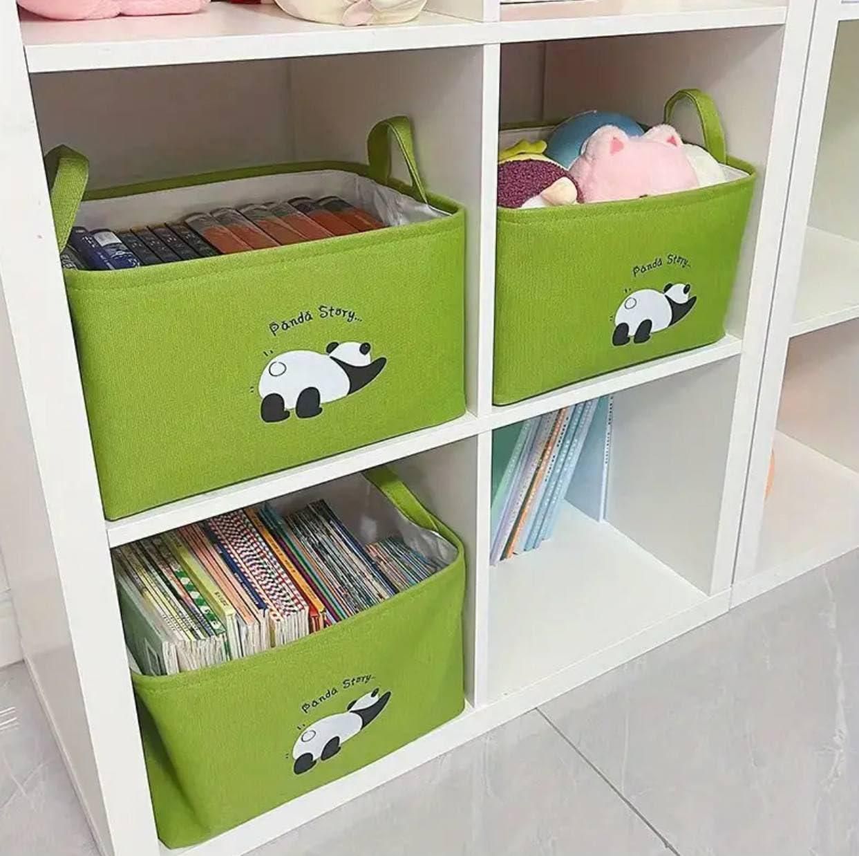 Green panda themed storage organizer bins with handles holding toys and books on white shelf