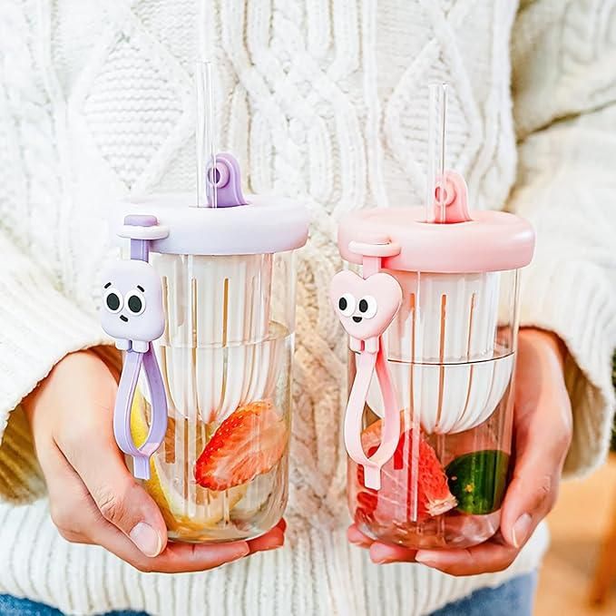 THE GIR FARMER glass smoothie tumbler with lid in pink and purple held with fresh fruit inside