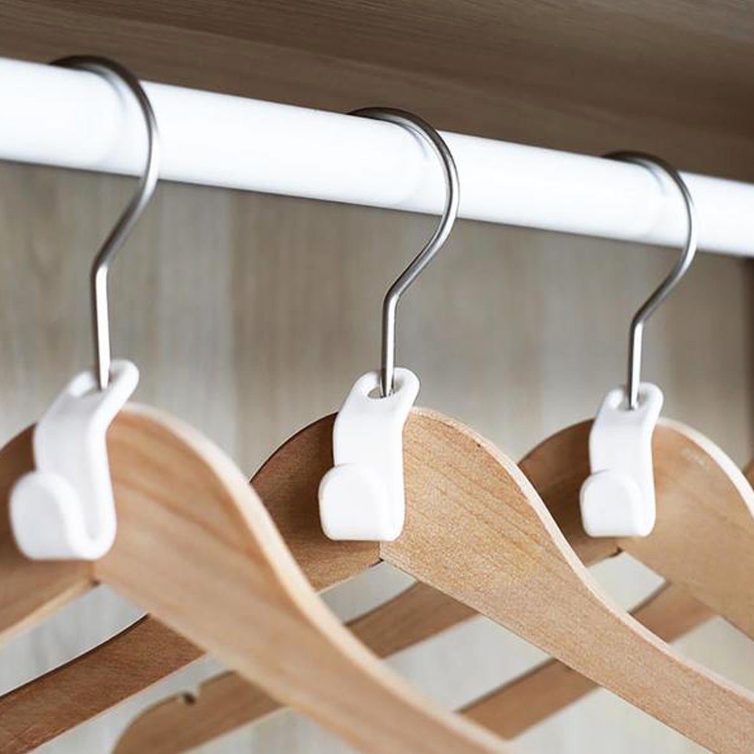 Plastic non-slip clothes hanger securely holding wooden clothes in a closet for organized storage