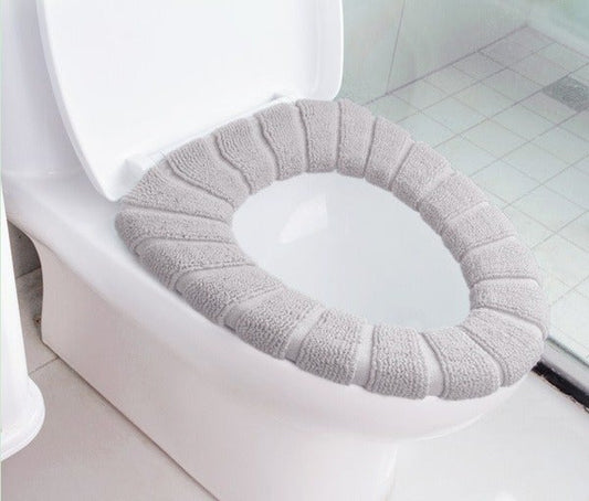 Soft and comfortable plush toilet seat cover in light gray for added bathroom warmth and style