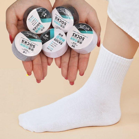 Set of five portable disposable travel socks displayed in hands with one sock on foot for convenience