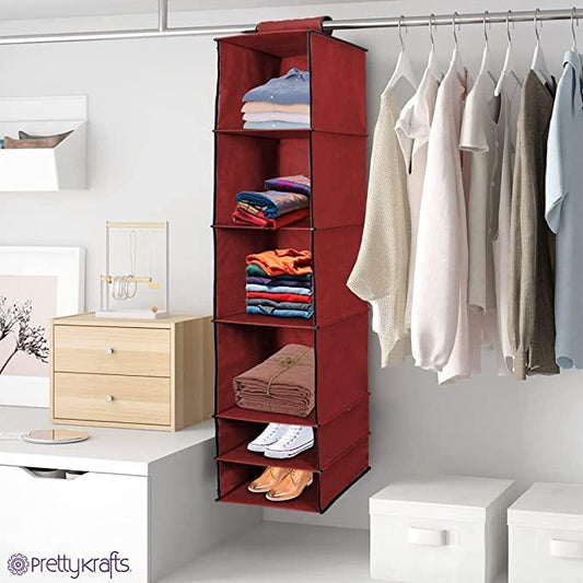 Maroon fabric wardrobe organizer hanging in closet with folded clothes and shoes neatly stored inside