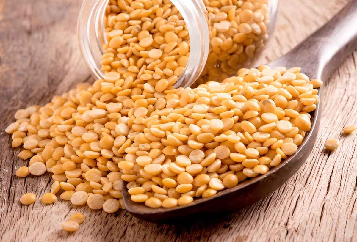 Pure natural tur dal in a wooden spoon with a jar, ideal for healthy cooking and nutritious meals