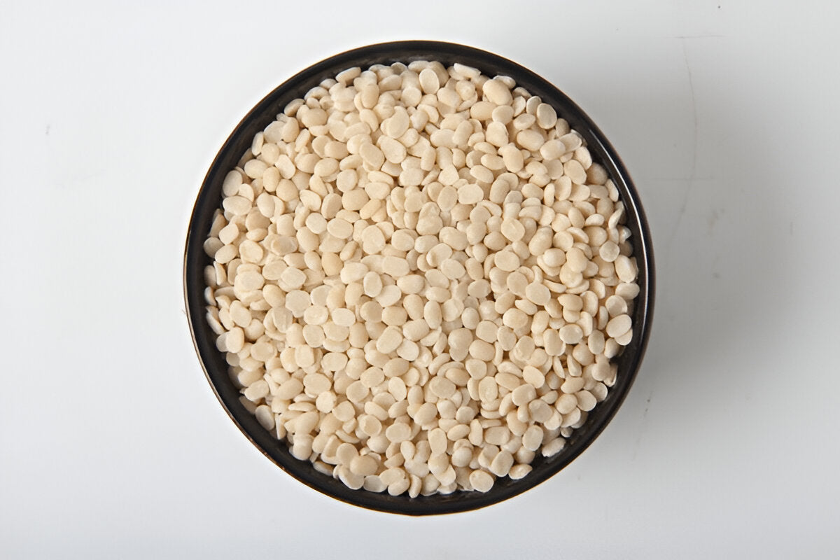 Pure urad dal for sale in a black bowl from THE GIR FARMER on a white background