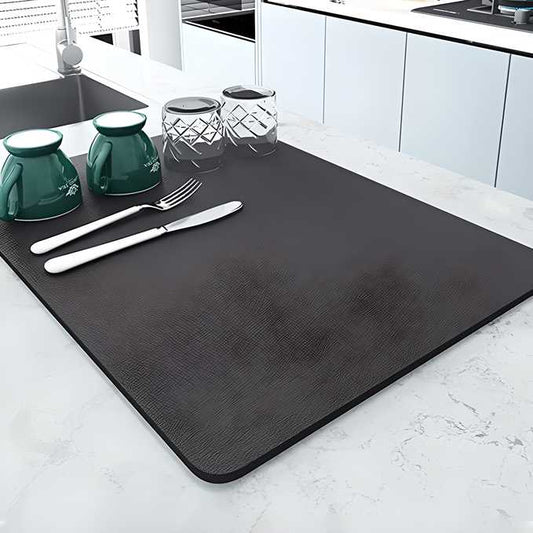 Stylish black quick drying kitchen mat on a marble countertop with dishware and utensils