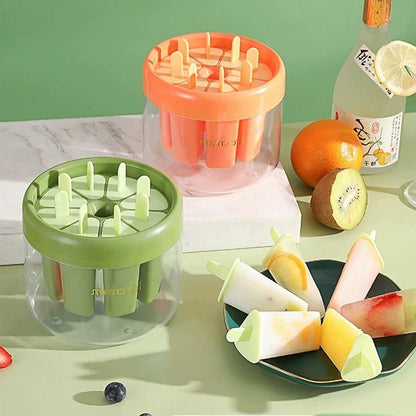 Colorful reusable ice pop molds in green and orange with finished popsicles on a plate
