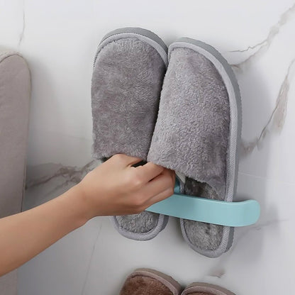 Self adhesive bathroom towel rack holding cozy gray slippers on a wall for easy access and storage