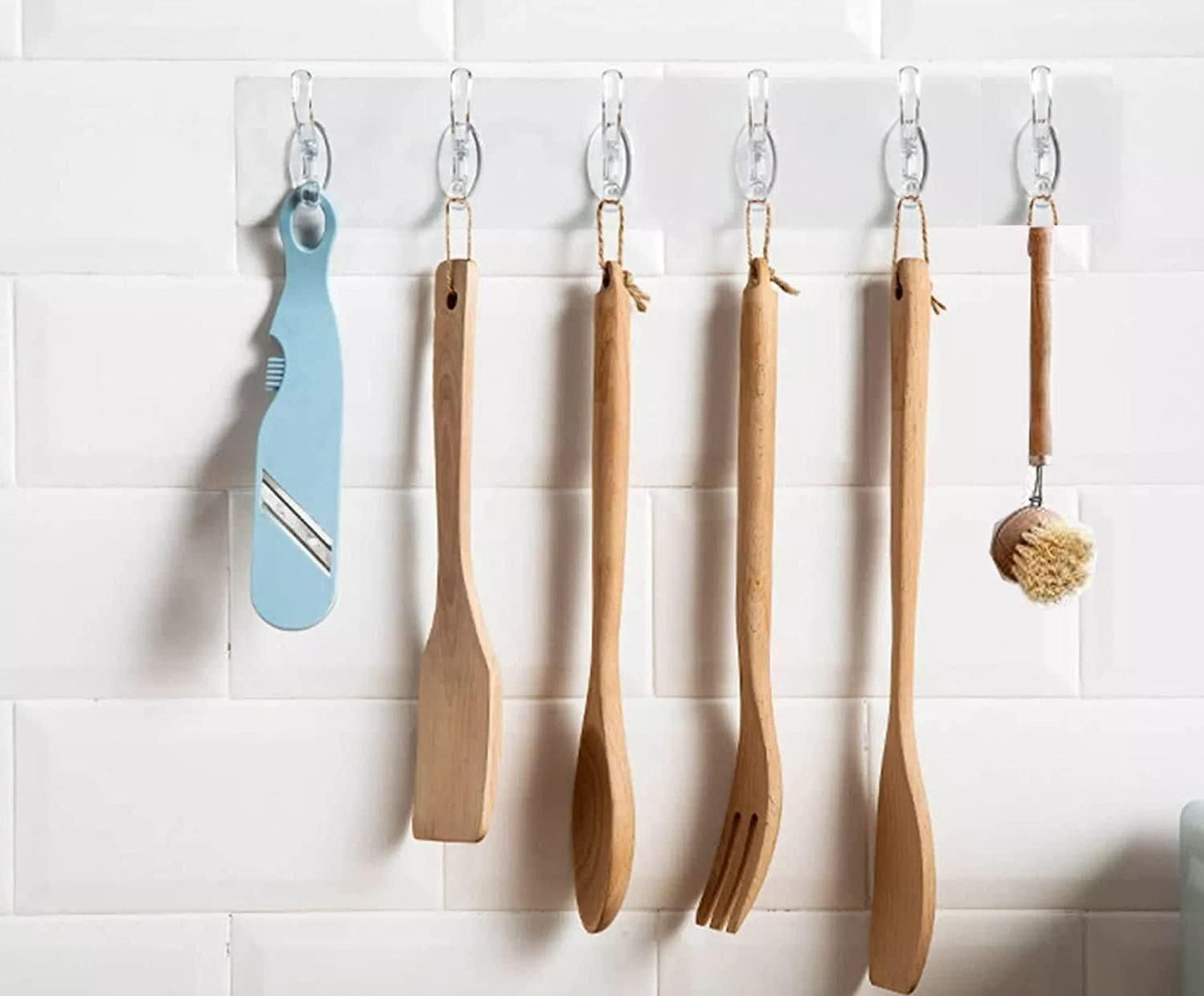 THE GIR FARMER self adhesive wall hanger hooks holding kitchen utensils and a blue peeler on white tile wall