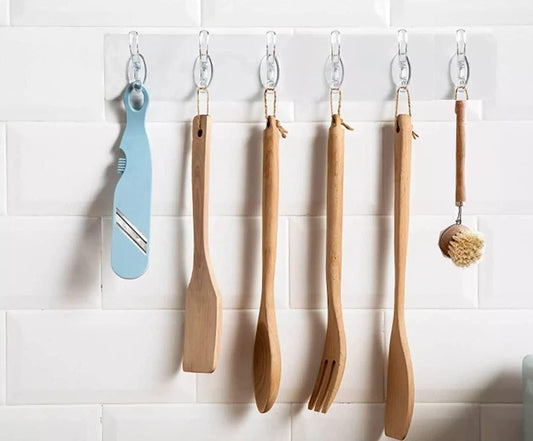 THE GIR FARMER self adhesive wall hanger hooks holding kitchen utensils and a blue peeler on white tile wall