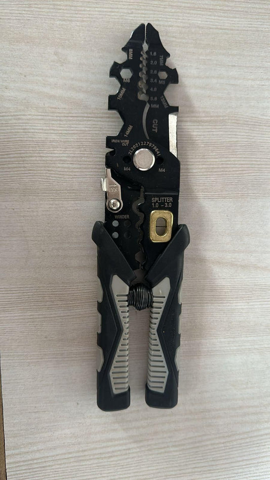 THE GIR FARMER multifunctional wire stripper tool with black ergonomic handles on wooden surface
