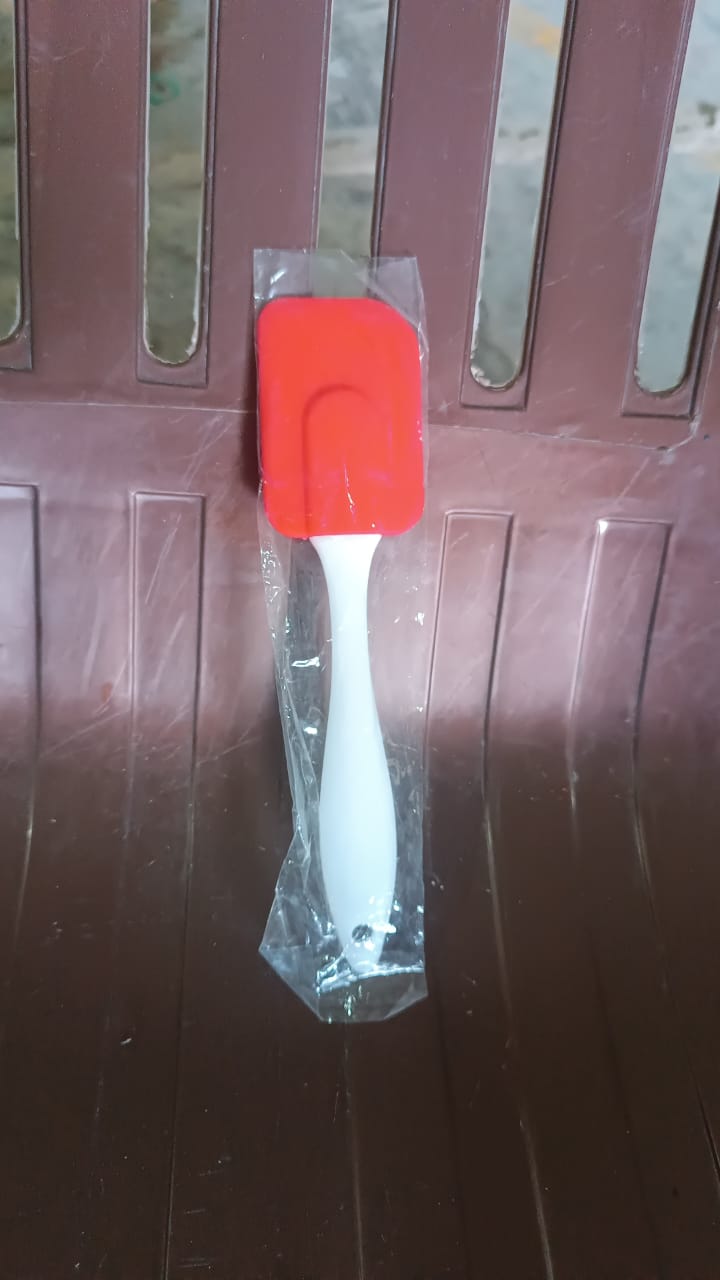Red silicone baking spatula with a white handle, perfect for mixing and scraping in the kitchen