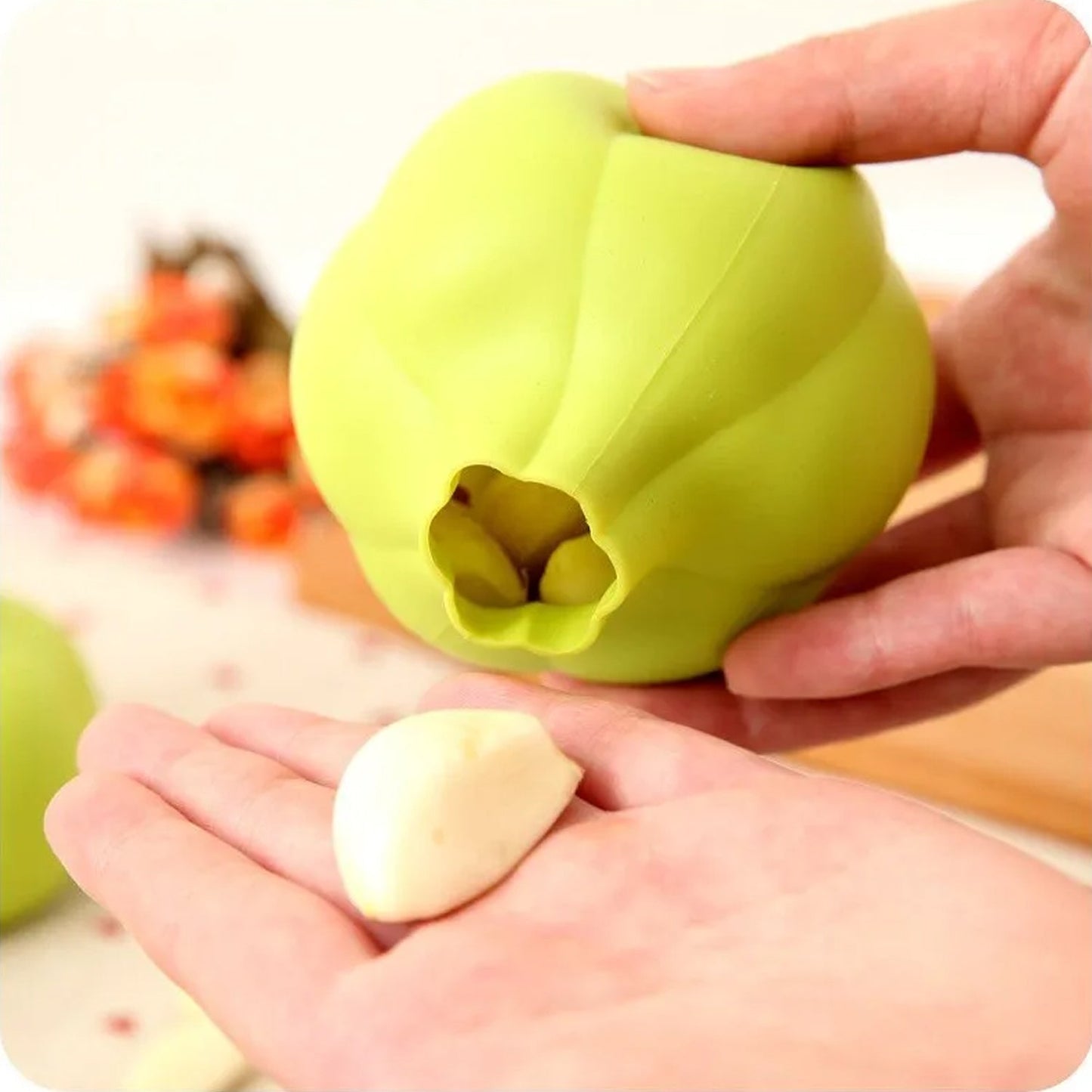 Silicone garlic peeler in green being used to peel a clove of garlic easily and quickly