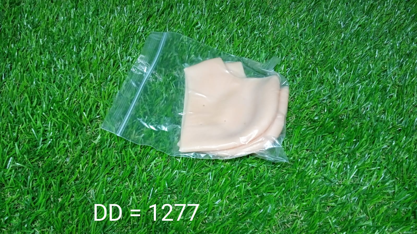 Your Brand silicone heel moisturizing socks in a clear package on green grass background