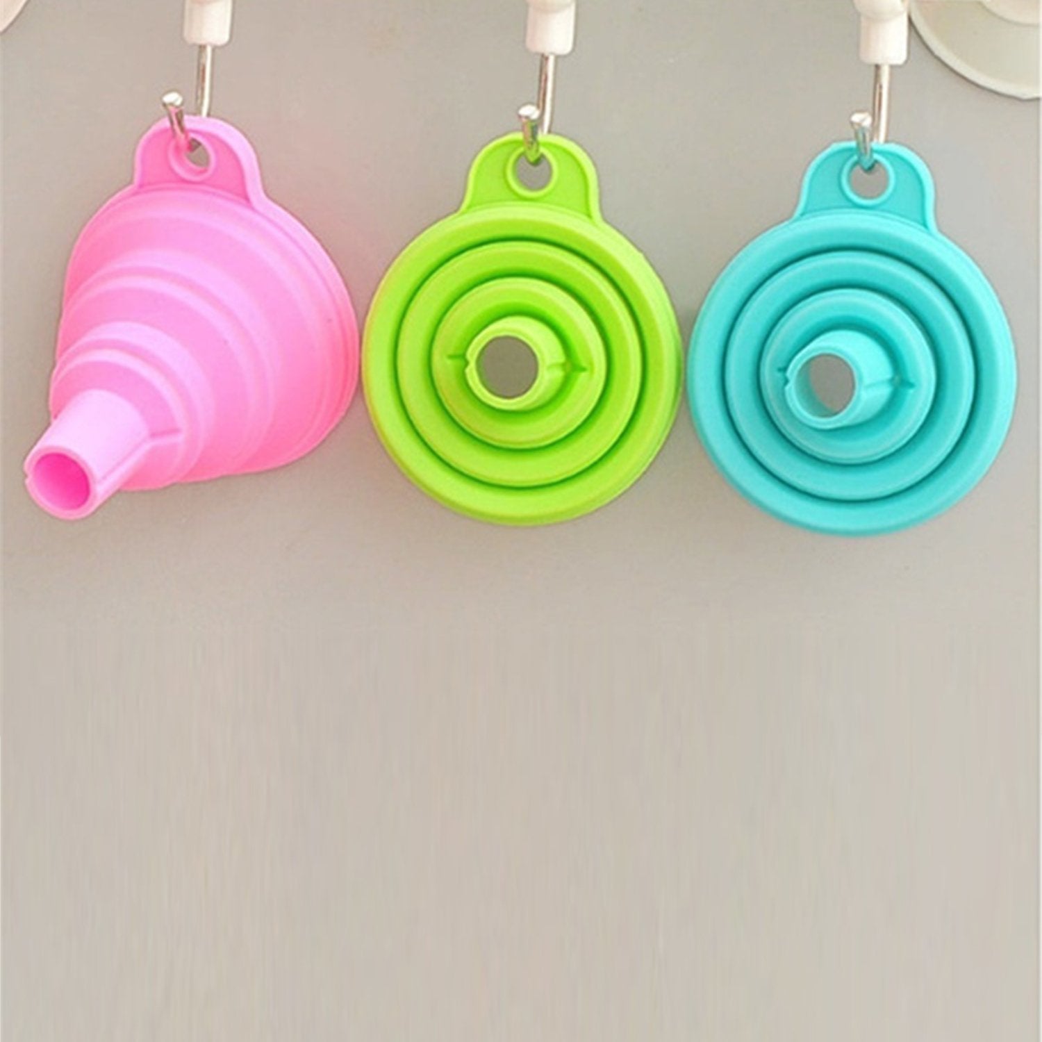 Set of three silicone kitchen funnels in pink, green, and blue, perfect for easy pouring and storage
