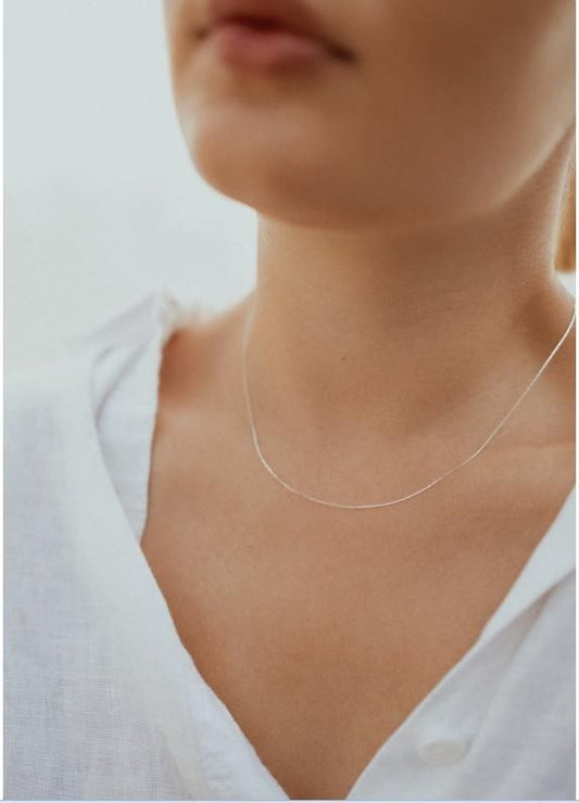 Elegant silver beading chain necklace worn on a model's neck with a white blouse