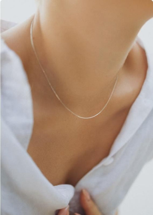Elegant silver beading chain necklace resting on a person's collarbone, showcasing its delicate design