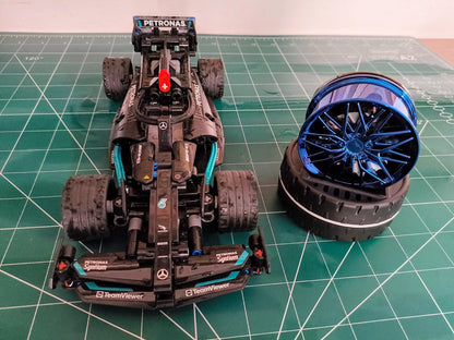Detailed model of a racing car with a blue wheel next to it, featuring a solar powered car air freshener
