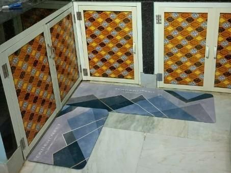 THE GIR FARMER rubber floor mat with geometric pattern in muted blue and gray tones placed on marble flooring