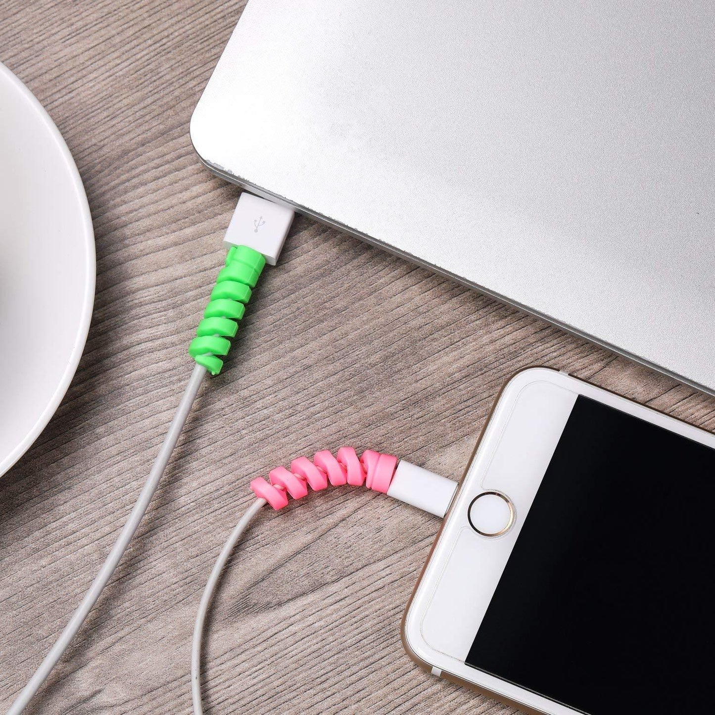Spiral charger cable protector in green and pink for preventing frays on charging cables