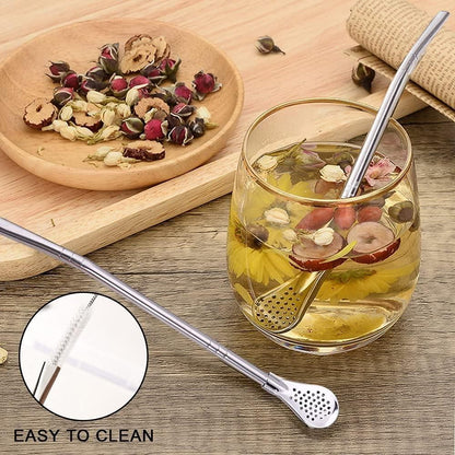 The Gir Farmer stainless steel drinking straws with built-in infuser and cleaning brush next to a glass of herbal tea